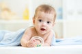 Baby with teether under blanket indoor