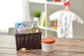 Baby things in basket on wooden table at home