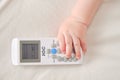 Baby toddler boy holds the air conditioner IGC remote control in his ha Royalty Free Stock Photo