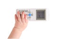 Baby toddler boy holds the air conditioner remote control in his hand, is Royalty Free Stock Photo