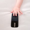 Baby toddler boy holds a computer mouse in his hand. Child with wirel Royalty Free Stock Photo