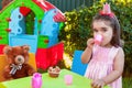 Baby toddler girl playing in outdoor tea party drinking from cup with best friend Teddy Bear Royalty Free Stock Photo