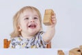 Baby toddler joyfully playing with wooden toys in children`s room on a light background concept of happy child, fun games Royalty Free Stock Photo