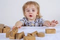 Baby toddler playing with wooden toys at home on light background concept happy child, fun games Royalty Free Stock Photo