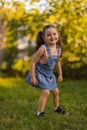 Baby toddler running on green lawn near the house. Royalty Free Stock Photo