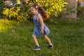 Baby toddler running on green lawn near the house. Royalty Free Stock Photo