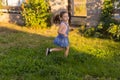 Baby toddler running on green lawn near the house. Royalty Free Stock Photo