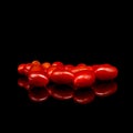 Baby tomatoes,cherry tomatoes and water drop on black background with reflection Royalty Free Stock Photo