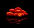 Baby tomatoes,cherry tomatoes and water drop on black background with reflection Royalty Free Stock Photo