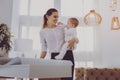 Little cute baby touching her industrious working parent in lighted room