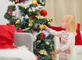 Baby touching Christmas ball on Christmas tree