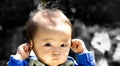 Baby touching his ears isolated on a black background and outdoors. Or hear no evil Royalty Free Stock Photo