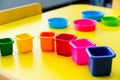 baby toy colored bucket on yellow table