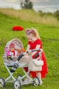 baby with toy stroller and doll Royalty Free Stock Photo