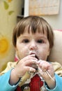 Baby tries to eat yoghurt independently Royalty Free Stock Photo