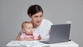 Baby tries to get attention from mother working on laptop Royalty Free Stock Photo