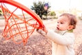 Baby tries to hit a ball in a basketball toy basket Royalty Free Stock Photo