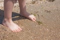 A baby try to step in to the sea water at the first time in a sunny day. With blurry sea background Royalty Free Stock Photo