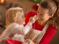 Baby trying to smear mothers nose with flour