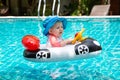 Baby turns the steering wheel. Summer vacation at sea. A little girl less than one year old is driving an inflatable boat in the Royalty Free Stock Photo