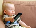 Baby and TV remote Royalty Free Stock Photo