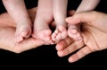 Baby Twins Feet in parents hands Royalty Free Stock Photo