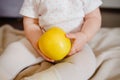 Baby two hands hold yellow apple. Toddler`s hands and fresh fruit front view. Flat lay diet and healthy food concept.