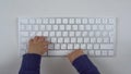 The baby is typing on the keyboard. Close-up child& x27;s hands typing on the keyboard. The keyboard is on the table top Royalty Free Stock Photo