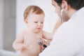 Baby visits the doctor. A male doctor examining an infant girl with a stethoscope. Royalty Free Stock Photo