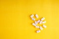 Baby vitamins in the form of bears fell out of the toy carts for products. On a bright yellow background. Pharmaceutical concept Royalty Free Stock Photo