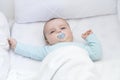 Baby waking up in his crib. A pacifier in his mouth. Royalty Free Stock Photo