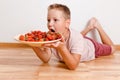 The baby wants to eat a lot of strawberries. hilarious photo of a boy and berries