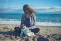 Baby wearing sunglasses on the beach with his mother Royalty Free Stock Photo