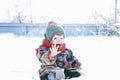 Baby in winter clothes outdoor remove her mittens and say hello. cute child in cap,scarf and mittens