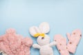 Baby winter clothes pink hat and mittens on blue background with white toy rabbit, copy space. christmas holiday Royalty Free Stock Photo