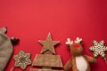 Baby winter hat, toy and wood snowflakes on red background with copy space. christmas child holiday