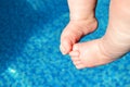 Baby& x27;s little feet in the water in the pool