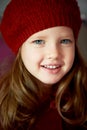 Baby 3 years old with blue eyes and white teeth in a red beret. Hair long