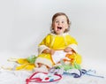 Baby in yellow rompers playing in studio