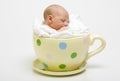 Baby in yellow spotted cup