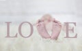 Babyfeet on fur forming the word love