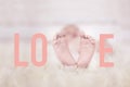 Babyfeet on fur forming the word love