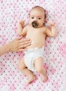 Hand applying body lotion to baby girl`s tummy Royalty Free Stock Photo