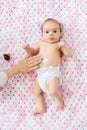 Hand applying body lotion to baby girl`s tummy Royalty Free Stock Photo