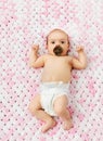 Baby girl in diaper lying with pacifier on blanket Royalty Free Stock Photo