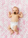 Baby girl in diaper lying with pacifier on blanket Royalty Free Stock Photo