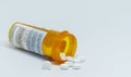 Pain pills spilling out of bottle with white background Royalty Free Stock Photo