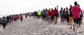 Rear view of runners and walkers on the sand at the beach