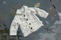 a babys knitted cardigan floating in warm, sudsy water
