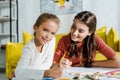 Babysitter looking at cute kid smiling in living room Royalty Free Stock Photo